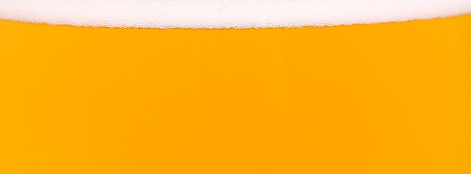 Light beer background. Is a thin strip of foam on top