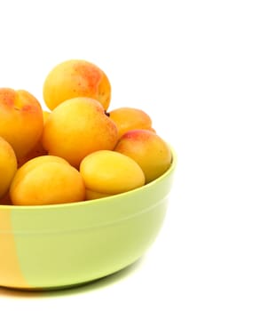 fresh apricot on a bowl are located left on the white background