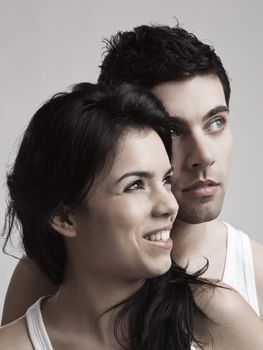 Happy young couple portrait over a gray background