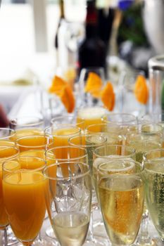 Elegant flutes of champagne and fresh orange juice on a wedding buffet table ready for toasting during the speeches