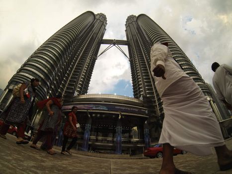 KUALA LUMPUR - MARCH  02:  man passing in front of Petronas Towers  at dusk  on March  2, 2013 in Kuala Lumpur, Malaysia