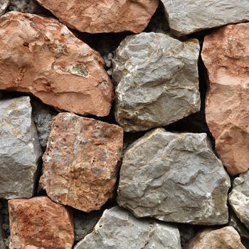 Large rough hewn natural stones and rocks interlocked without mortar forming a garden wall