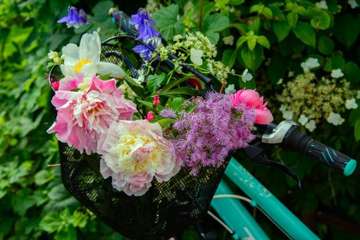 A bicycle with a basket filled with summer flowers from a garden