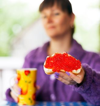 woman with red caviar sandwich in her hand