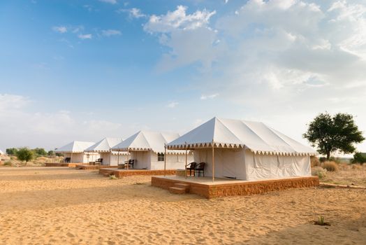 Tent camping site hotel for tourist  in the thar desert under blue sky