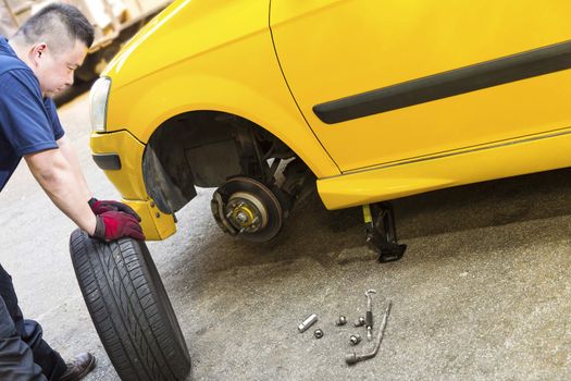 A mechanic looking troubled is preparing to change tire