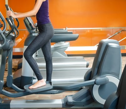 Girl training in gym on a step machine