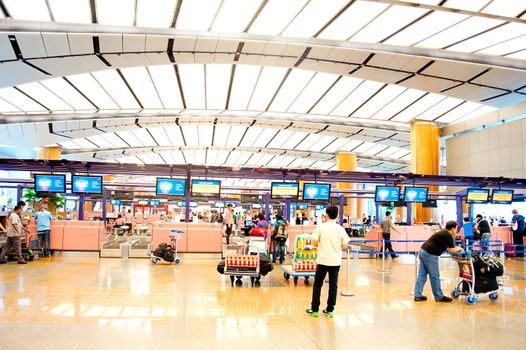 Singapore, Republic of Singapore - March 05, 2013: People at Check in counter at Changi International Airport. Changi Airport serves more than 100 airlines operating 6,100 weekly flights