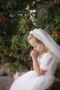 A young child praying during her first holy communion