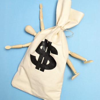 A dummy is crushed by a large bag of money.