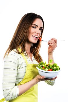 Young Woman Cooking and eating healthy Food - Vegetable Salad. Diet. Dieting Concept. Healthy Lifestyle. Cooking At Home. Prepare Food 