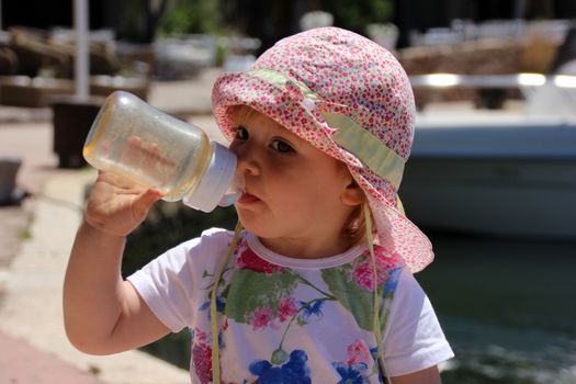 Portrait of little cute blond girl (one year and seven months of age) on the port