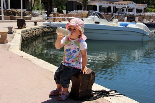 Portrait of little cute blond girl (one year and seven months of age) on the port