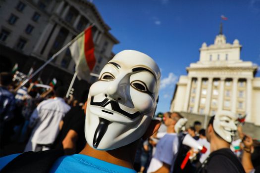 Sofia; Bulgaria - June 16, 2013: Bulgarian wearing anonymous mask protest on "Independence" square, where Council of ministers building is, demanding their newly appointed socialist government step down.
The protests were originally sparked by the controversial appointment of businessman and MP Delyan Peevski as the new head of the State Agency for National Security.