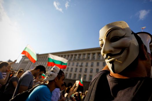 Sofia; Bulgaria - June 16, 2013: Bulgarian wearing anonymous mask protest on "Independence" square, where Council of ministers building is, demanding their newly appointed socialist government step down.
The protests were originally sparked by the controversial appointment of businessman and MP Delyan Peevski as the new head of the State Agency for National Security.