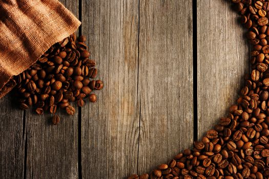 Coffee beans and bag over wooden background