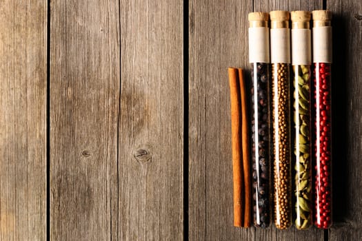Spices in beakers on wooden background