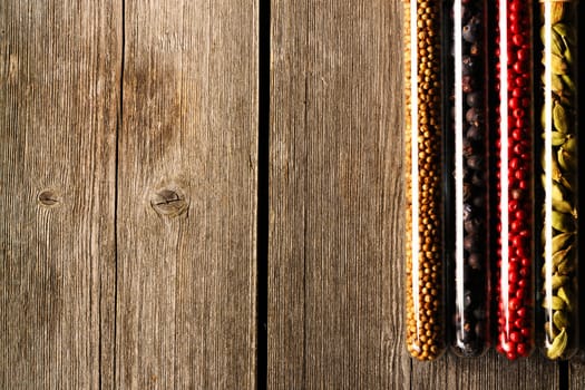 Spices in beakers on wooden background