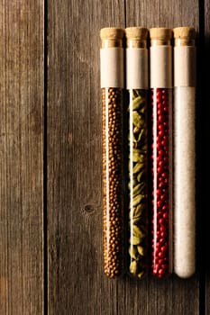 Spices in beakers on wooden background