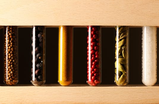 Spices in beakers against dark background