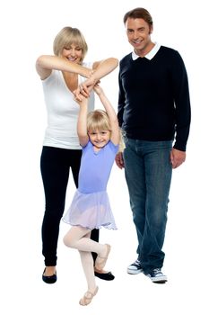Young parents helping their daughter dance