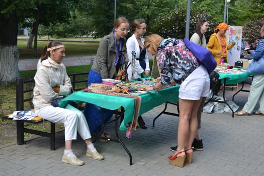 Girls examine goods on a street counter