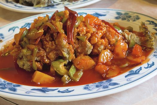 Deep Fried Whole Fish Chinese Dish with Bell Peppers Pineapple Red Ginger and Sweet and Sour Sauce Closeup