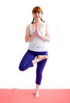 middle aged redhead woman exercising yoga isolated on white