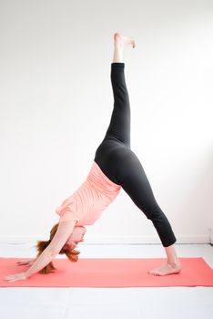 middle aged redhead woman exercising yoga isolated on white