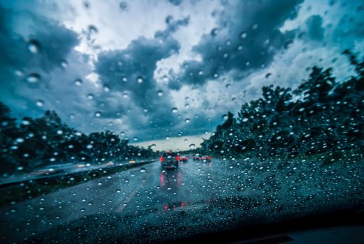 dramtatic sky and clouds with some rain while driving on a highway