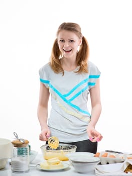 The beautiful young cheerful girl on home cuisine cooks dough for easter pie