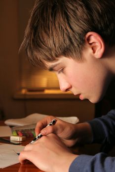 The boy doing lessons and with concentration drawing