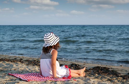 little girl sitting on beach