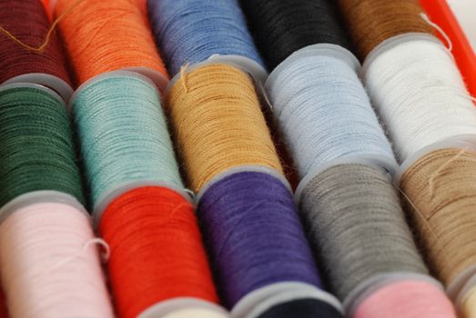 colorful spools of multi colored threads for sewing and knitting