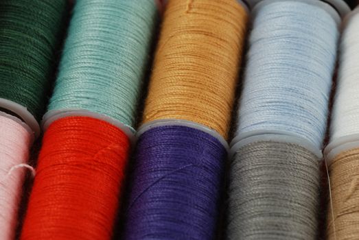 colorful spools of multi colored threads for sewing and knitting