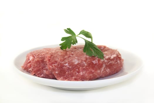 raw minced meat and parsley on a white plate