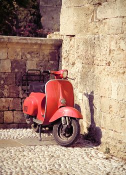 Red vintage scooter on old stone paved street