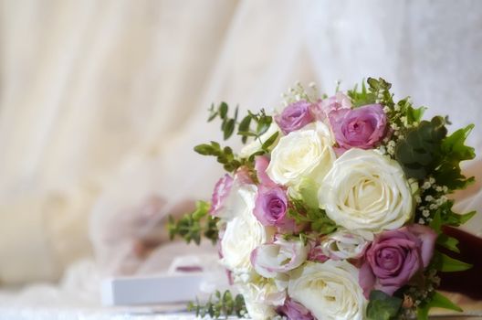 Wedding bouquet made of white and pink roses on table