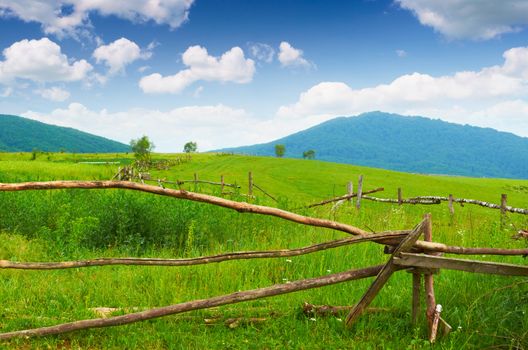 Wooden fence on pasture in the mountains