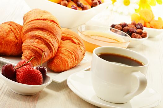 Breakfast with croissants, cup of coffee and fruits