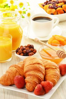 Breakfast with croissants, cup of coffee and fruits