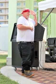 Big biker man dancing to music at a biker rally outdoors.