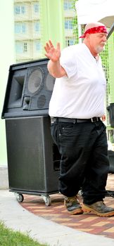 Big biker man dancing to music at a biker rally outdoors.