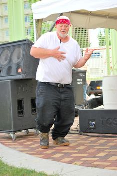 Big biker man dancing to music at a biker rally outdoors.