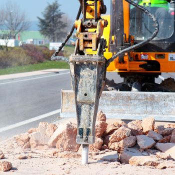 yellow jackhammer working on the road