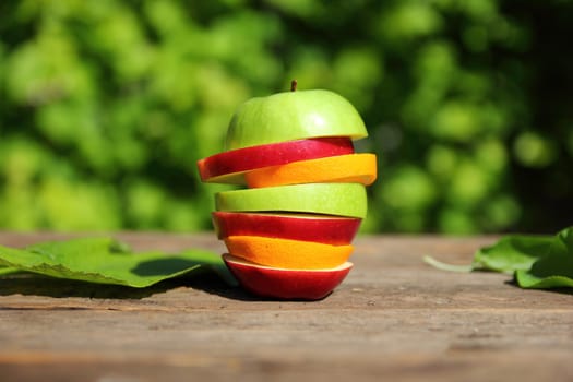 pieces of fruit on a table on a background of green trees