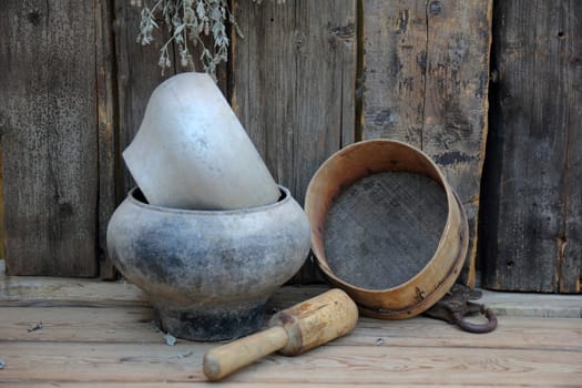 pots, kitchen utensils, a sieve against the boards