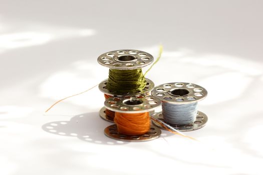 several reels of multi-colored threads for sewing