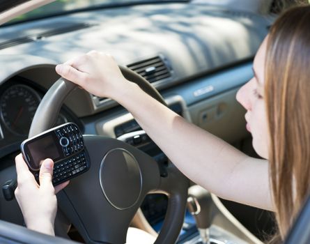 Teenage girl texting on cell phone while driving