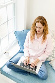 Caucasian woman using laptop computer sitting on couch at home